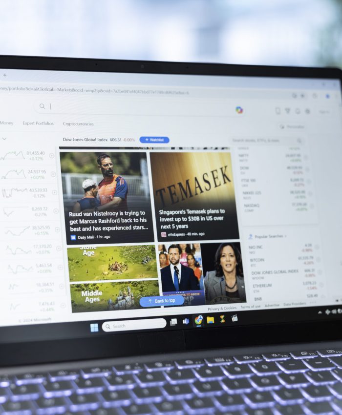 Bucharest, Romania - July 30th 2024 - Young CEO reading the online news on a webpage, using Microsoft Start to stay informed on worldwide updates. Man using online digital service.